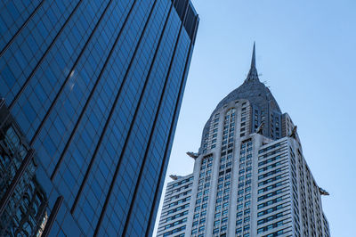 Low angle view of modern buildings against clear blue sky