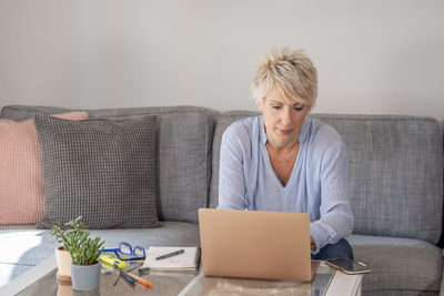 Woman using laptop on couch at home