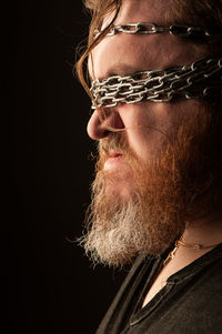 Close-up portrait of man against black background