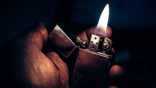 Cropped hand lighting cigarette lighter