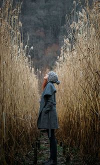 Rear view of woman standing on field