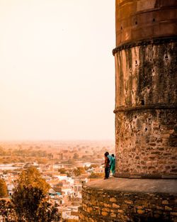 Side view of woman against buildings in city