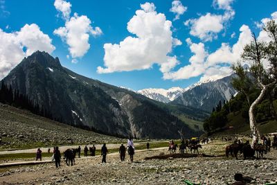 People on mountains against sky