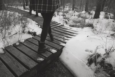 Low section of person standing on snow covered steps