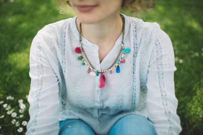 Midsection of woman sitting outdoors