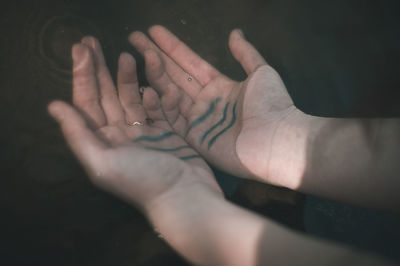 Close-up of hand touching finger against black background