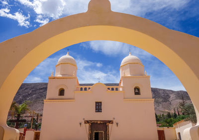 Low angle view of bell tower amidst buildings against sky