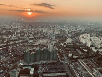 Aerial view of illuminated cityscape against sky during sunset