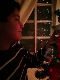 Portrait of boy with christmas tree at home