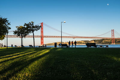 People walking along the footpath beside the tagus river in lisbon, portugal. 