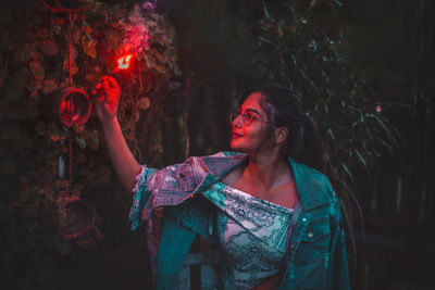 Young woman looking up at night