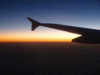 Cropped image of silhouette airplane against sky during sunset