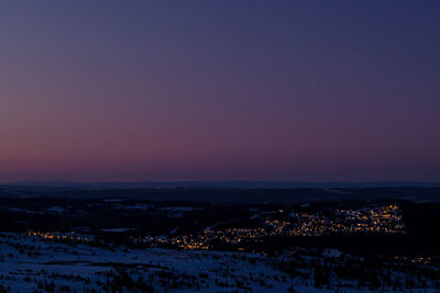 Aerial view of illuminated city at sunset