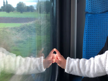 Midsection of man with train window