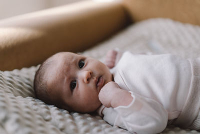 Portrait of a 1 month old baby. cute newborn baby lying on a developing rug.