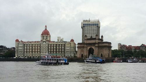 Boats in river with buildings in background