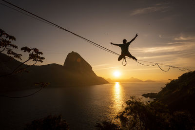 Beautiful sunrise view of man walking on highline with sugar loaf