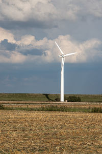 Windmill on field against sky