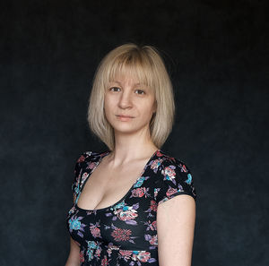 Portrait of young woman against black background