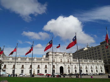 Low angle view of red flags against sky