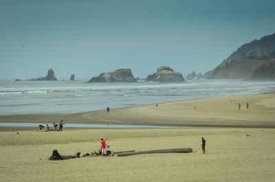 People on beach against clear sky