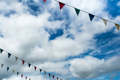 Low angle view of flags hanging against sky