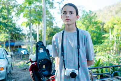 Pretty and cute girl sitting and taking photos alone, carrying a camera, thai teen idol.