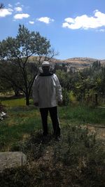 Rear view of woman standing on field