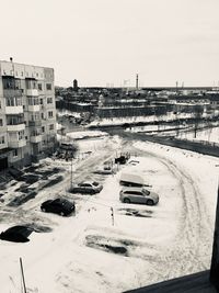 Cars on street by buildings in city against clear sky