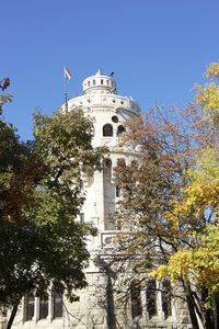 Low angle view of trees and building against sky