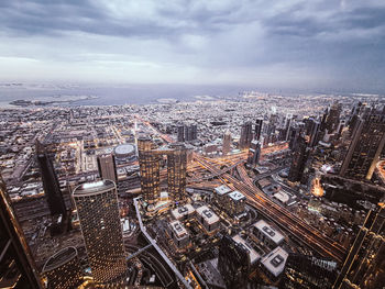 High angle view of city buildings against cloudy sky