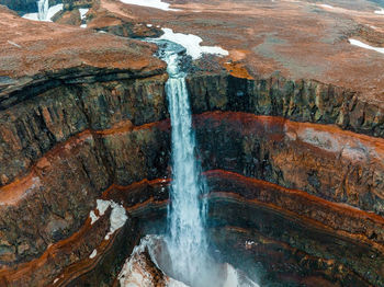 Aerial view on hengifoss waterfall with red stripes sediments in iceland.