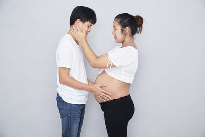 Young couple standing against white background