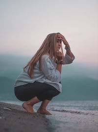 Woman wearing sunglasses at beach against sky