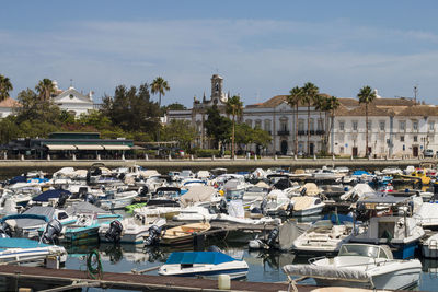 Boats moored in city against sky