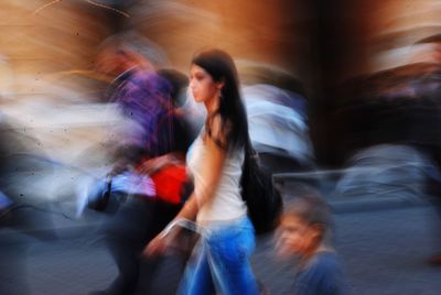 Blurred motion of people walking on street in city