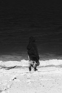 Rear view of man walking on beach