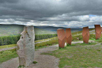 Wooden posts on field against sky