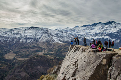 People on snowcapped mountains against sky