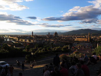 People at town square against sky during sunset