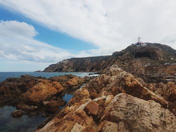 Rock formations by sea against sky