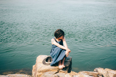 High angle view of woman sitting by lake