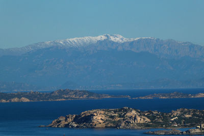 Scenic view of sea and snowcapped mountains against sky