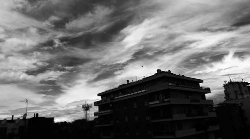 Low angle view of buildings against cloudy sky