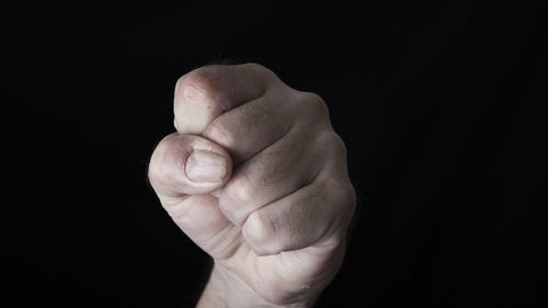 Close-up of fist against black background