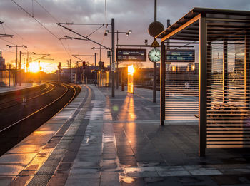 Railroad station against sky during sunset