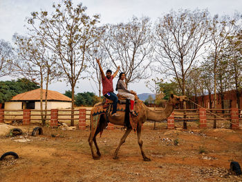 Man riding horse on field against sky