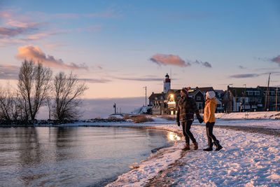 Man standing on snow against sky during sunset