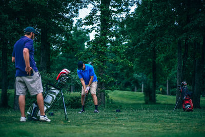 Friends playing with golf ball in forest