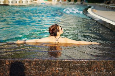 Rear view of woman in swimming pool